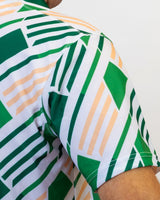 Close-up of a green and white geometric patterned golf shirt with a blurred background
