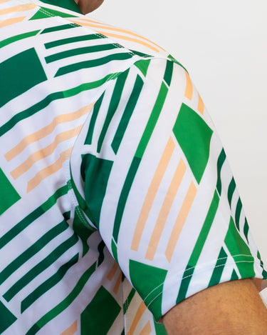 Close-up of a green and white geometric patterned golf shirt with a blurred background