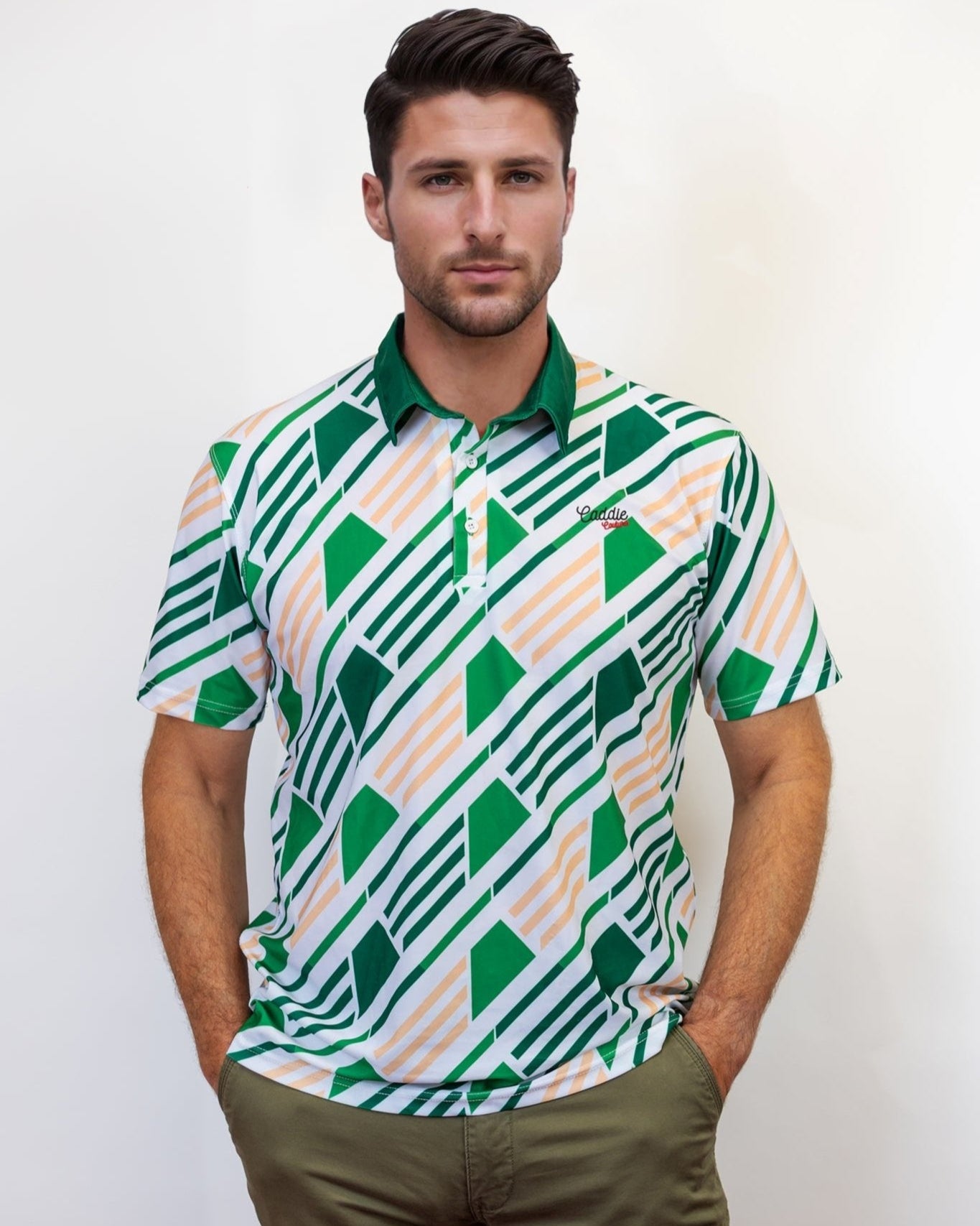 Man wearing a patterned green and white golf shirt with a plain background