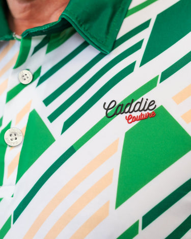 Close-up of a green and white patterned golf shirt with 'Caddie Couture' branding.