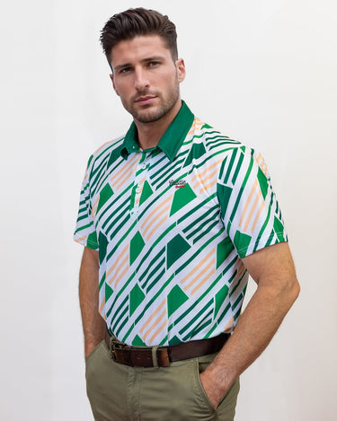 Man wearing a patterned golf shirt with geometric design on a plain background