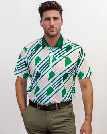 Man wearing a patterned golf shirt and green pants against a white background