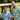 Two men in patterned shirts sitting in a golf cart on a golf course