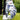Golf glove with blue and white pattern holding a golf ball on grass