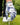 Golf glove with blue and white pattern holding a golf ball on grass