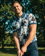 Man in a floral shirt holding a golf club on a golf course