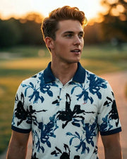 Man wearing a floral polo shirt standing outdoors with a blurred background