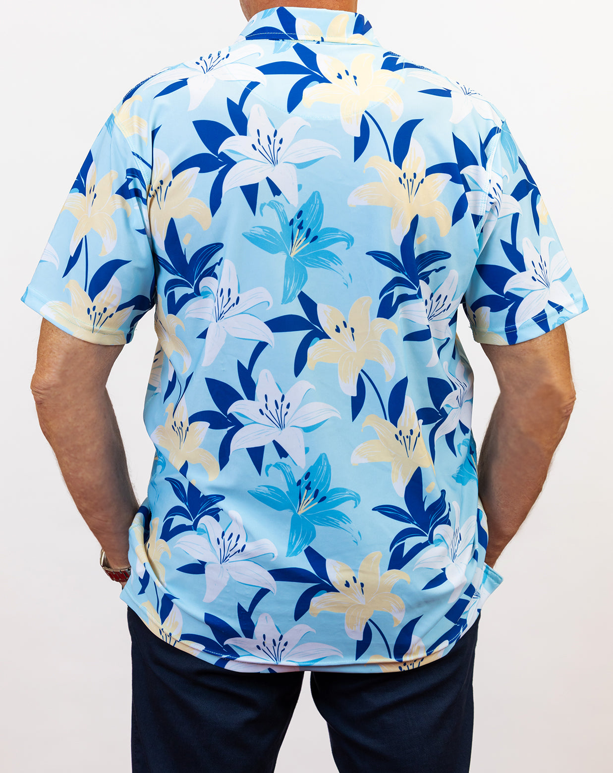 Person wearing a blue floral patterned golf shirt on a plain background