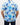 Person wearing a blue floral patterned golf shirt on a plain background
