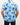 Person wearing a blue floral patterned golf shirt on a plain background