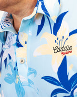 Golf Polo with floral design and 'Caddie Couture' branding on a light blue background