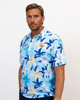 Man wearing a blue floral patterned golf shirt on a plain background