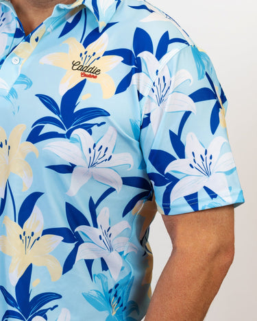 Blue floral patterned golf shirt with 'Caddie couture' branding on a plain background