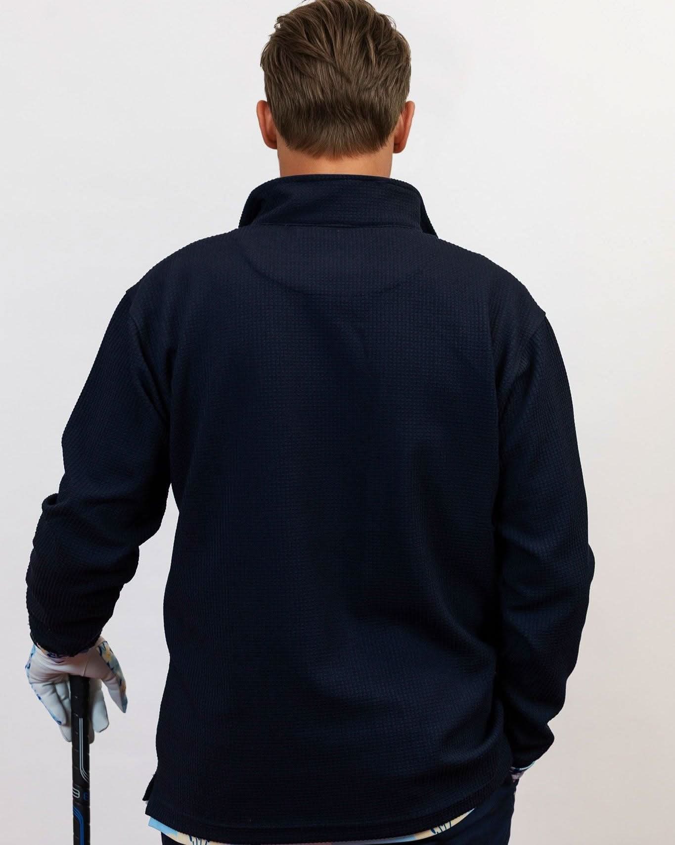 Man wearing golf quarter zip with floral pattern. holding golf club