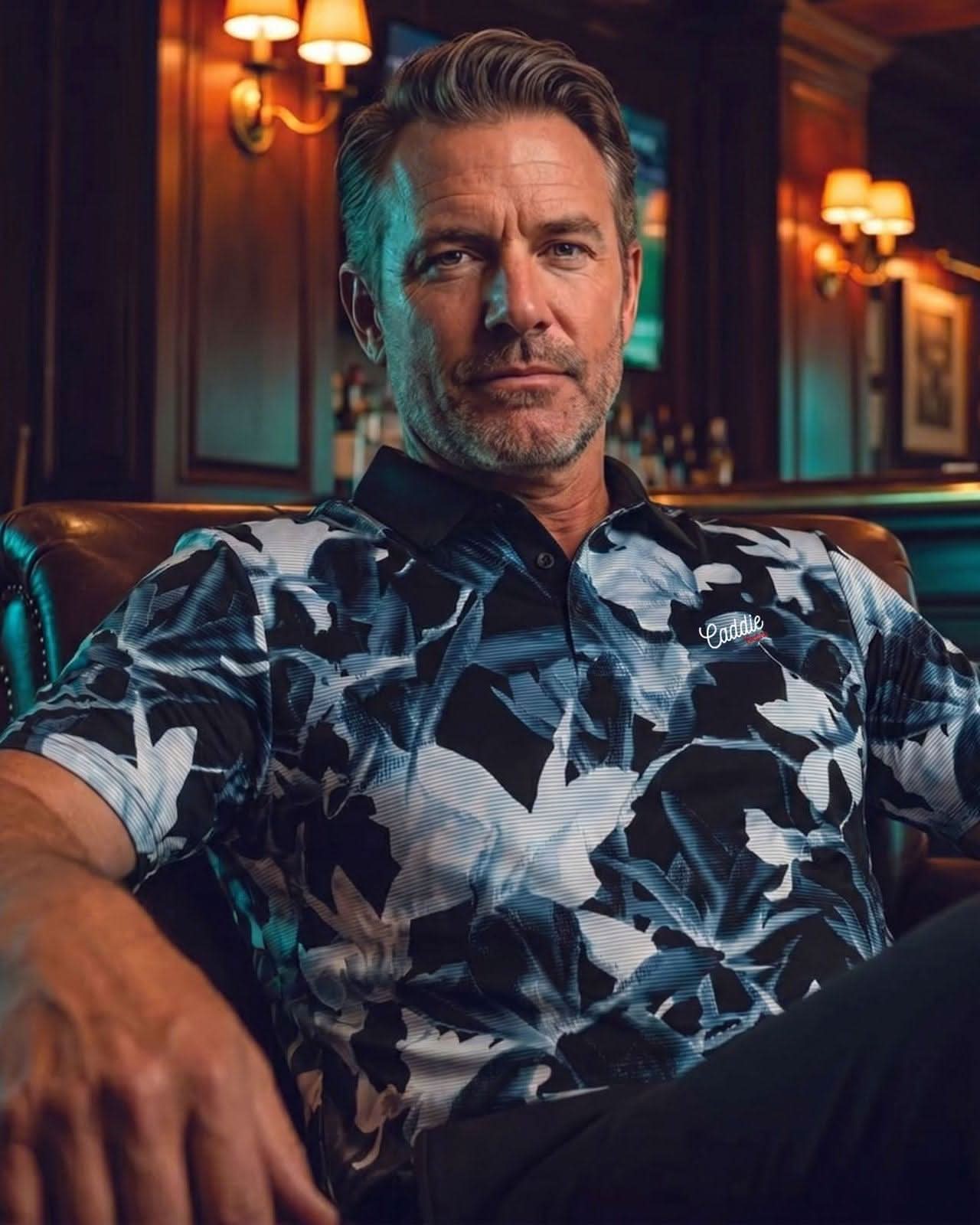 Man wearing a patterned shirt sitting in a bar.