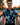 Man wearing a patterned shirt with a blurred outdoor background