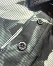 Close-up of a grey shirt with buttons and 'Caddie Couture' branding.