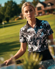 Woman in a floral shirt standing outdoors with a blurred background
