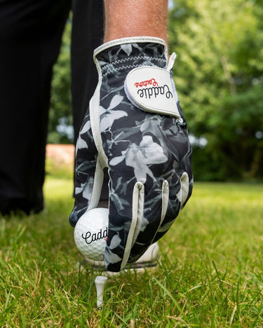 Golf glove and ball on a tee with a blurred green background