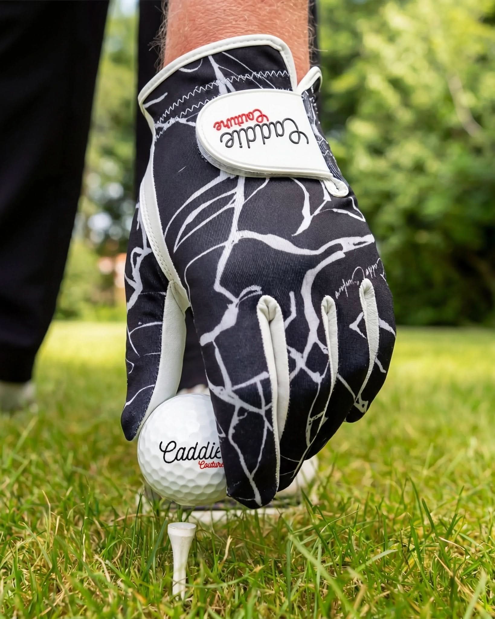 Golf glove and ball on grass with 'Caddie Couture' branding
