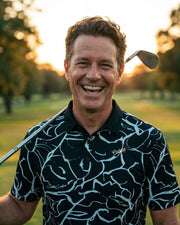 Man holding a golf club on a golf course with a blurred background