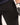 Close-up of black pants and a white sneaker with black pattern on a light background
