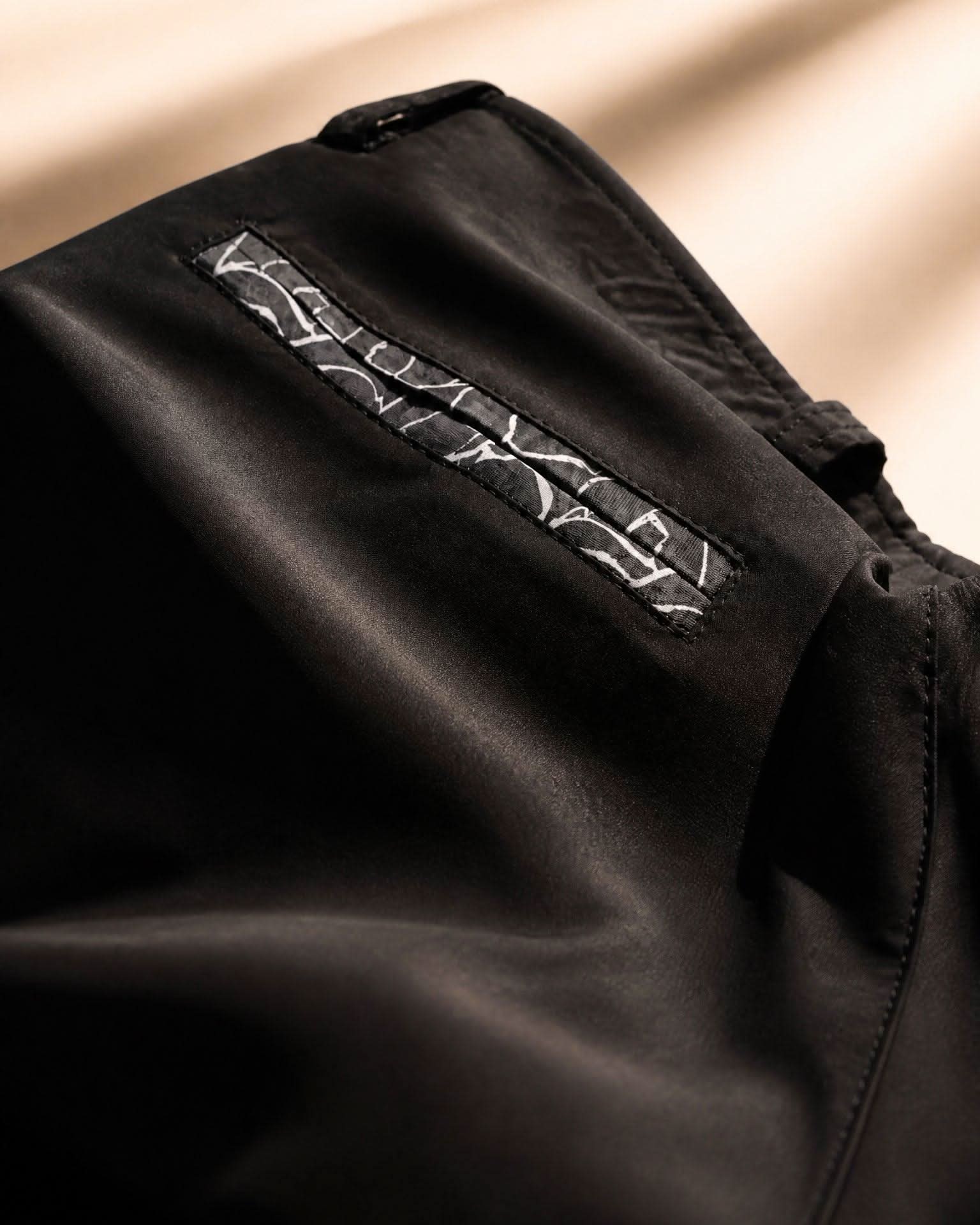 Close-up of black fabric with a textured pattern on a beige background