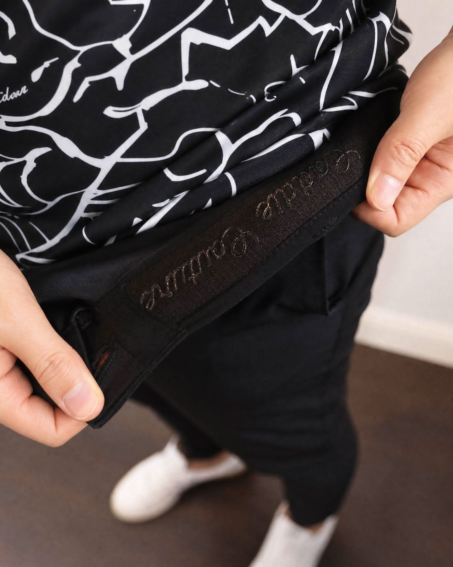 Person holding a black and white patterned bag with visible branding.