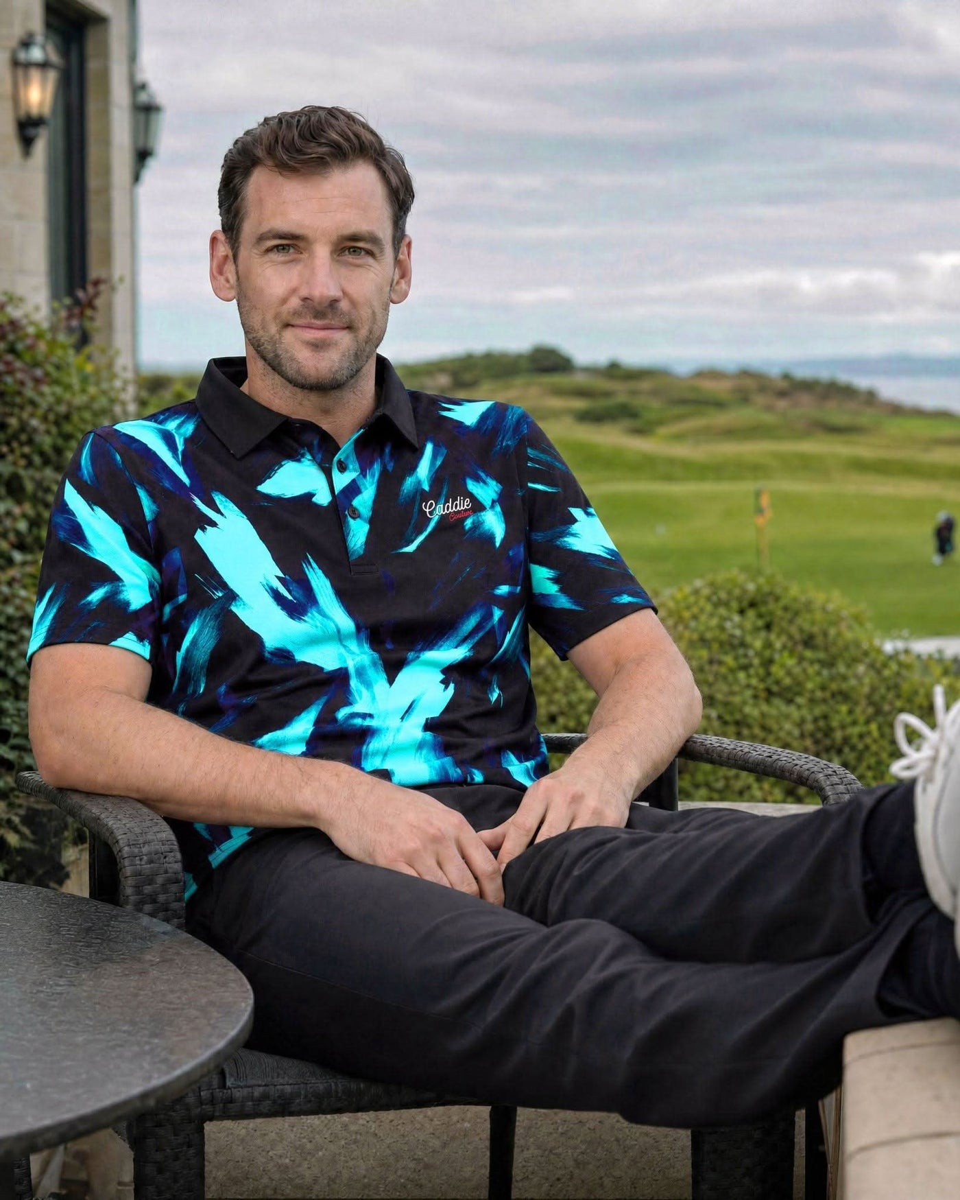Man sitting on a chair with a golf course in the background