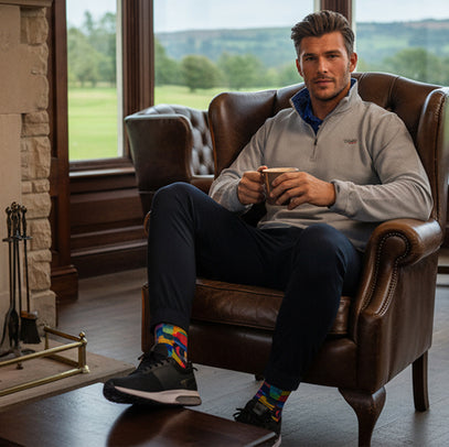 man sitting in chair drinking coffee