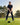 Man playing golf on a green course with trees in the background