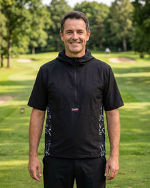 Man wearing a black hoodie with a logo on a golf course