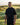 Man in black hoodie standing on a golf course with scenic background