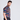A man wearing a short-sleeved multicolor geometric patterned golf polo shirt. side view