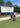 Two golfers posing with a golf bag in front of a large scoreboard at the Senior PGA Championship.