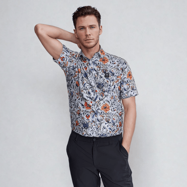male model with arm behind back wearing a vintage floral golf polo shirt