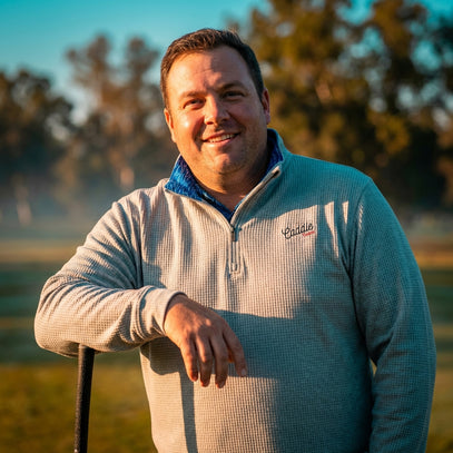 man wearing grey waffle quarter zip on golf course
