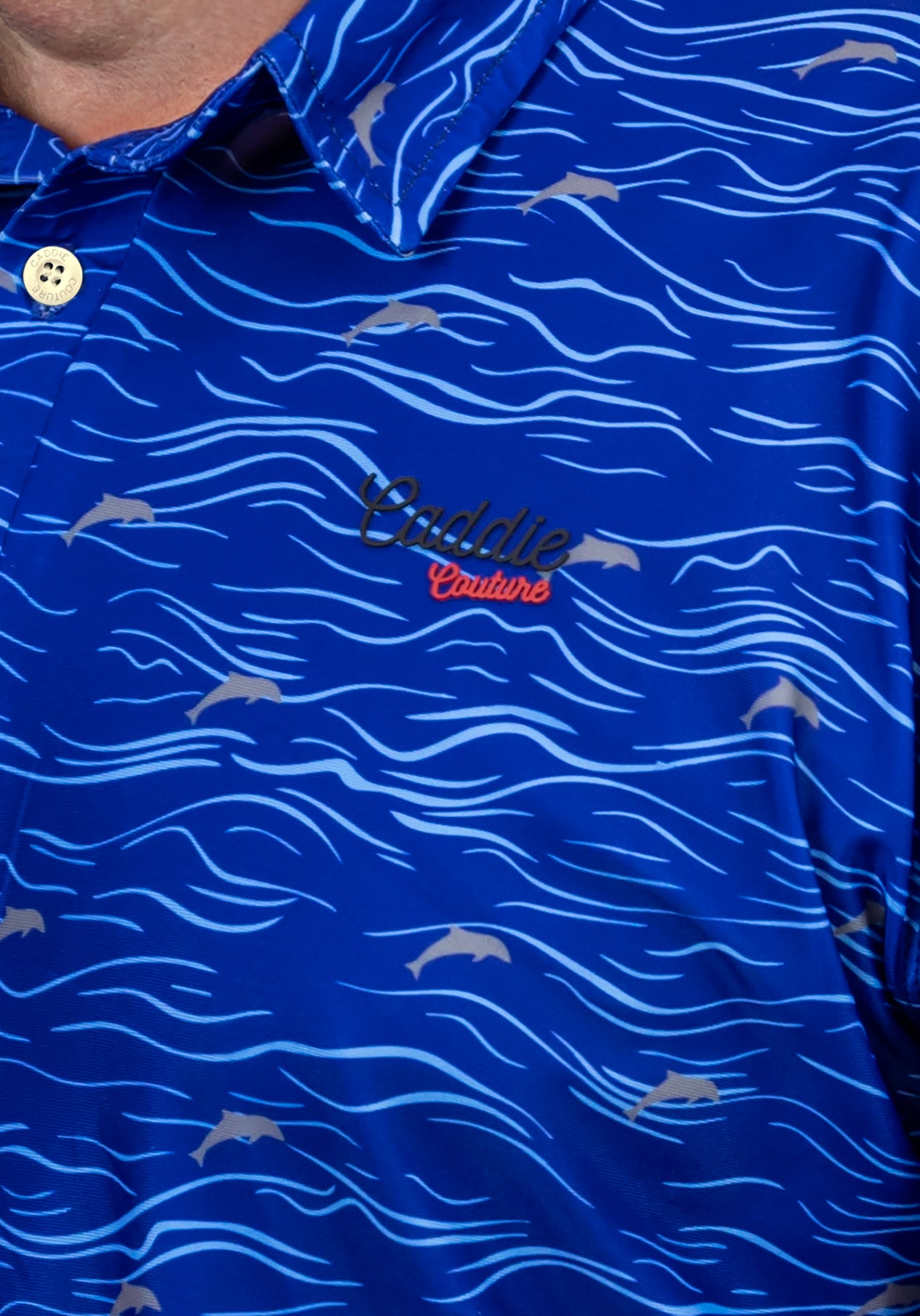 Blue polo shirt with wave pattern and 'Caddie Couture' logo