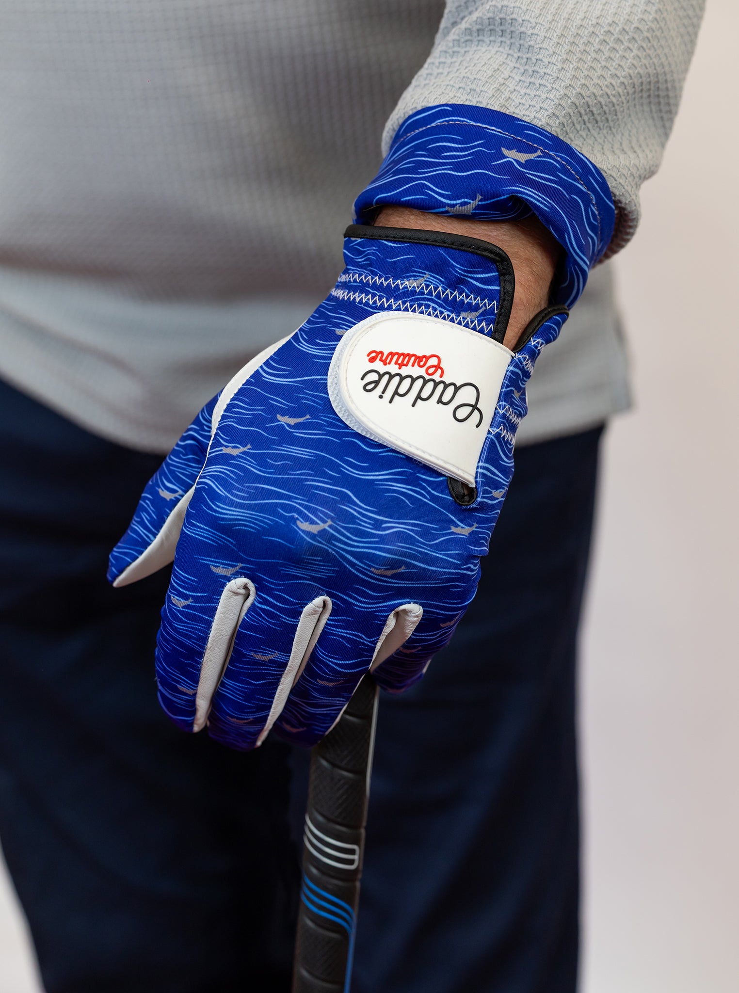 Blue golf glove with a white label on a blurred background