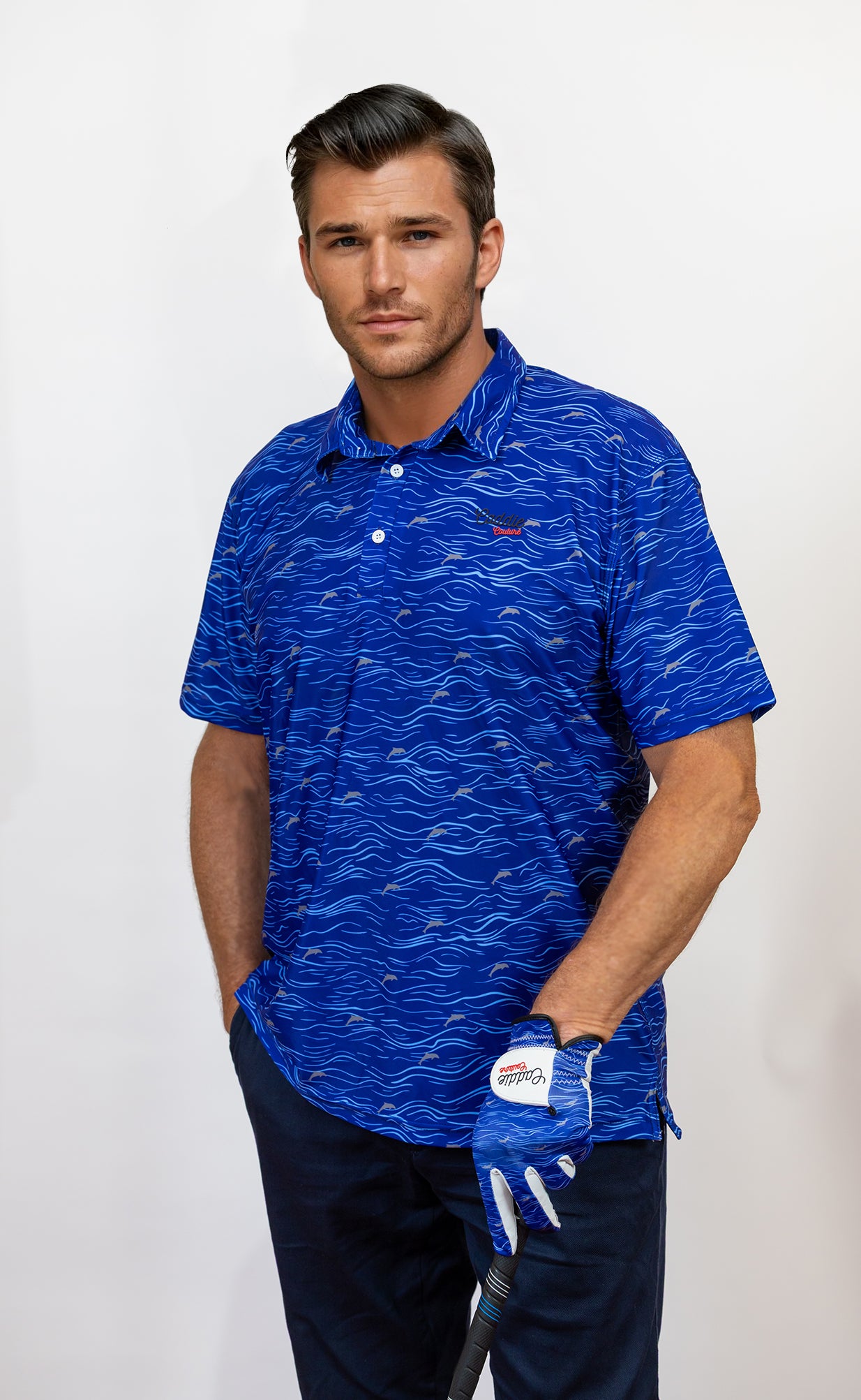 Man wearing a blue patterned golf polo shirt with a golf glove on a white background